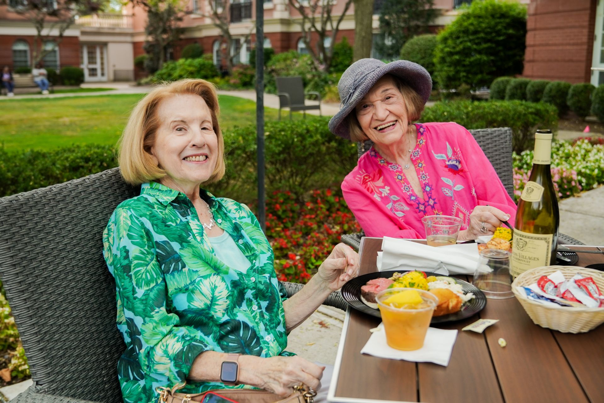 Two residents of The Osborn joyfully dine outdoors during an event