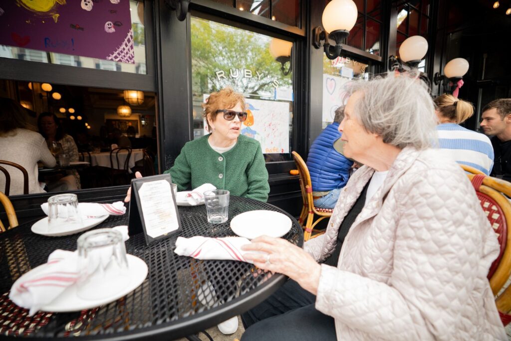 Two Osborn residents dine outside at a restaurant in Rye, New York