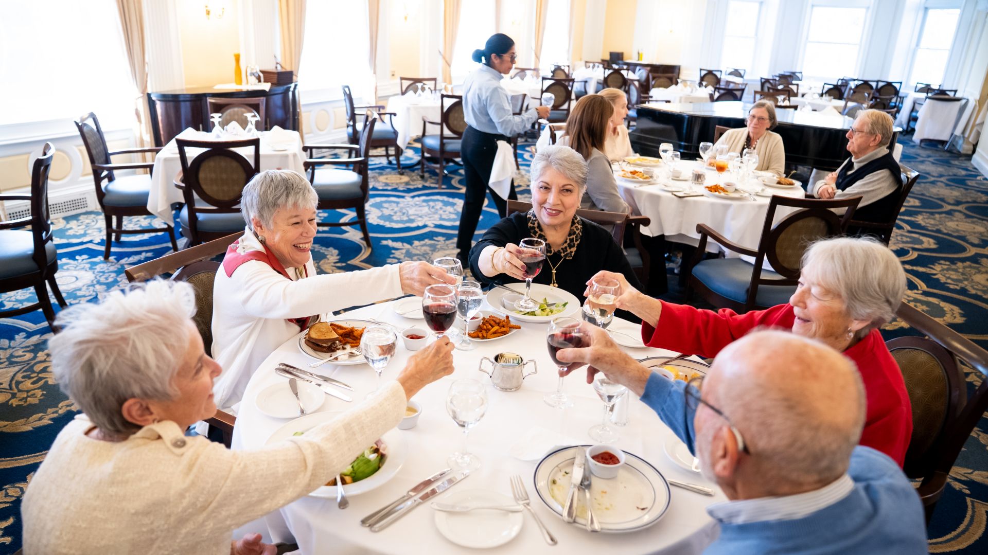 Residents of The Osborn raise a toast in the formal dining room after enjoying lunch