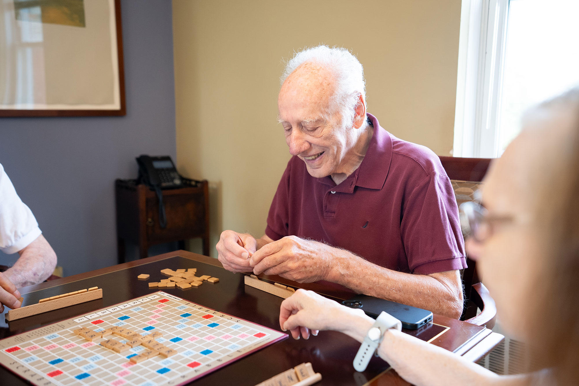 Assisted living resident enjoying a Scrabble game at The Osborn
